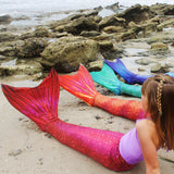 Girls in mermaid tails on the beach